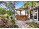 An awesome backyard bar complete with chairs and a wooden pergola offers the perfect outdoor entertaining space at 1166 Granada St, Clearwater, FL 33755