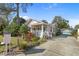 Charming exterior of the home with a well-maintained yard, a welcoming porch, and a long driveway at 1166 Granada St, Clearwater, FL 33755