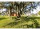 Spacious back yard with mature trees and an installed swing set at 13481 Pullman Dr, Spring Hill, FL 34609