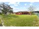 Large grassy back yard with mature trees and an installed play set at 13481 Pullman Dr, Spring Hill, FL 34609