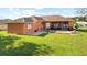 Back yard features a covered brick patio with comfortable seating and a grill at 13481 Pullman Dr, Spring Hill, FL 34609