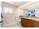 Bathroom featuring a glass block window, a wide mirror, and a handrail by the toilet at 13481 Pullman Dr, Spring Hill, FL 34609