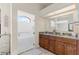 Bathroom featuring a walk-in shower with a glass door, a double sink, and wood cabinets at 13481 Pullman Dr, Spring Hill, FL 34609