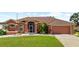 Charming single-story home featuring a well-manicured lawn, two car garage, and a screened in front entryway at 13481 Pullman Dr, Spring Hill, FL 34609