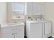 Functional laundry room with sink, cabinets and modern washer and dryer at 13481 Pullman Dr, Spring Hill, FL 34609