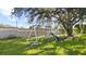 Swing set in large back yard surrounded by manicured landscaping and mature trees at 13481 Pullman Dr, Spring Hill, FL 34609