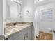 Bright bathroom featuring a granite countertop, updated vanity, and shower with subway tile at 1404 Wood Ave, Clearwater, FL 33755