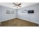 A spacious bedroom with hardwood floors, two windows, and a ceiling fan at 1404 Wood Ave, Clearwater, FL 33755