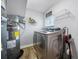 Convenient laundry area featuring modern washer and dryer, storage shelving, and a water heater at 1404 Wood Ave, Clearwater, FL 33755