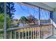 Balcony view overlooking a serene lake; features a screened enclosure, metal railing and an array of trees at 1411 Water View W Dr, Largo, FL 33771