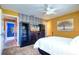 Bright bedroom featuring brick accent wall, ceiling fan and display cabinets at 1411 Water View W Dr, Largo, FL 33771