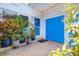 Inviting entrance with potted plants, tiled floor, and a vibrant blue front door at 1411 Water View W Dr, Largo, FL 33771