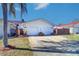 Charming single-story villa with a white exterior, two-car garage, and well-maintained front yard at 1411 Water View W Dr, Largo, FL 33771