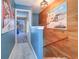 Hallway featuring wood wall and access to a bright, open living space with serene outdoor views at 1411 Water View W Dr, Largo, FL 33771