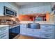 Well-equipped kitchen with stainless steel appliances, white cabinetry, and an open view to the living area at 1411 Water View W Dr, Largo, FL 33771