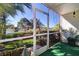 Relaxing screened lanai with views of a serene lake, lush greenery, and artificial turf at 1411 Water View W Dr, Largo, FL 33771