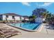 Community pool featuring clear blue water, lounge chairs, and a bathhouse on a bright, sunny day at 1411 Water View W Dr, Largo, FL 33771