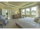 Bright main bedroom with a tray ceiling, large windows, and an ensuite bathroom at 14466 Pioneer Ridge Dr, Hudson, FL 34667