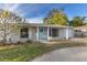 Charming single-story home with a bright teal front door, white columns, and a well-maintained front yard at 1859 Nevada Ne Ave, St Petersburg, FL 33703