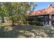 A charming backyard with a lush lawn, shade tree, and a screened lanai with a red tile roof at 19029 Us Highway 19 N # 19C, Clearwater, FL 33764