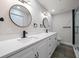 Elegant bathroom featuring double sinks, modern fixtures, and stylish round mirrors for a luxurious feel at 19029 Us Highway 19 N # 19C, Clearwater, FL 33764
