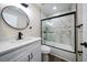 Modern bathroom with a tub-shower combo featuring marble-look tile, glass door, and sleek black fixtures at 19029 Us Highway 19 N # 19C, Clearwater, FL 33764