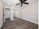 Neutral bedroom featuring wood-look floors, a ceiling fan, and a mirrored closet creating an open and airy feel at 19029 Us Highway 19 N # 19C, Clearwater, FL 33764
