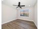 Bright bedroom with wood-look floors, ceiling fan, and a large window offering plenty of natural light at 19029 Us Highway 19 N # 19C, Clearwater, FL 33764