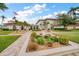 A lush landscaped path leading to a community building with an American flag and palm trees at 19029 Us Highway 19 N # 19C, Clearwater, FL 33764