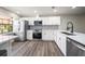 Bright kitchen with stainless steel appliances, white cabinets, and mosaic backsplash at 19029 Us Highway 19 N # 19C, Clearwater, FL 33764