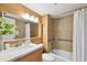 Bathroom with wood-look tile walls, floating vanity, stone countertop, and decorative vase with flowers at 2 Adalia Ave # 602, Tampa, FL 33606