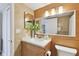 Bathroom with wood-look tile walls, floating vanity, stone countertop, and decorative vase with flowers at 2 Adalia Ave # 602, Tampa, FL 33606