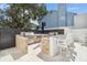 Outdoor kitchen featuring stone counter with bar seating and a stainless steel grill with travertine pavers at 2 Adalia Ave # 602, Tampa, FL 33606