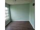 Bright bedroom featuring wood-look floors, fresh paint, baseboard, and a window for natural light at 2043 Denmark St # 77, Clearwater, FL 33763
