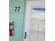 Unit #77 front door with a fire extinguisher mounted on the siding, and a storm door at 2043 Denmark St # 77, Clearwater, FL 33763