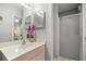 Well-lit bathroom featuring a sink, mirrored storage, and enclosed shower at 2218 Mayfield Palms Ln # 323, Sun City Center, FL 33573