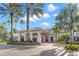 A grand entrance to the community clubhouse with lush landscaping at 2218 Mayfield Palms Ln # 323, Sun City Center, FL 33573