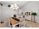 Elegant dining room featuring a wooden table, white chairs, a hutch, and decorative plant accents at 2218 Mayfield Palms Ln # 323, Sun City Center, FL 33573