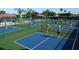 Aerial view of multiple pickleball courts with players in action on a sunny day at 2218 Mayfield Palms Ln # 323, Sun City Center, FL 33573