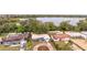 An aerial view showcasing the property's location near a serene lake surrounded by lush greenery and neighboring homes at 2405 Indigo Dr, Clearwater, FL 33763