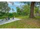 Backyard area with chairs, pea gravel, large oak tree, and wooded view at 2405 Indigo Dr, Clearwater, FL 33763