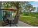Outdoor patio area with dining table, chairs, and view of the backyard at 2405 Indigo Dr, Clearwater, FL 33763