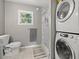 Cozy bathroom with a white tiled shower, gray walls, and stacked washer and dryer at 2835 Valencia S Way, St Petersburg, FL 33705