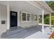 Inviting covered front porch with a dark-colored door and a view of the well-kept yard at 2835 Valencia S Way, St Petersburg, FL 33705