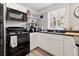 Efficient kitchen with black appliances, white cabinetry, and sleek countertops, perfect for cooking at 2835 Valencia S Way, St Petersburg, FL 33705