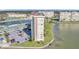 Aerial view of a tall condo building, parking, and a scenic body of water at 4775 Cove Cir # 205, St Petersburg, FL 33708