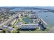 Wide aerial view of a condominium complex, landscaping, with a large lake and partial ocean view at 4775 Cove Cir # 205, St Petersburg, FL 33708