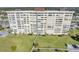 Multi-story condominium building featuring a manicured lawn, walkway, and parking area at 4775 Cove Cir # 205, St Petersburg, FL 33708