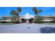 Low angle shot of a commercial building with a beige exterior, palm trees, and a parking lot at 4775 Cove Cir # 205, St Petersburg, FL 33708