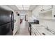 Functional kitchen with black appliances, laminate floors, and view into the living area at 4775 Cove Cir # 205, St Petersburg, FL 33708